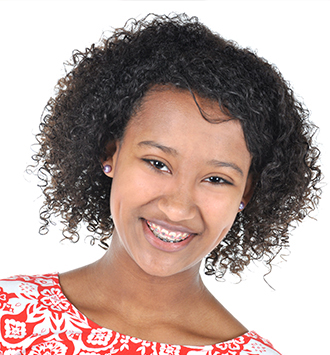 Young woman smiling at camera wearing red patterned shirt, professional headshot portrait
