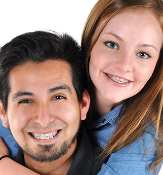 Two smiling people posing together for a portrait photo against white background.