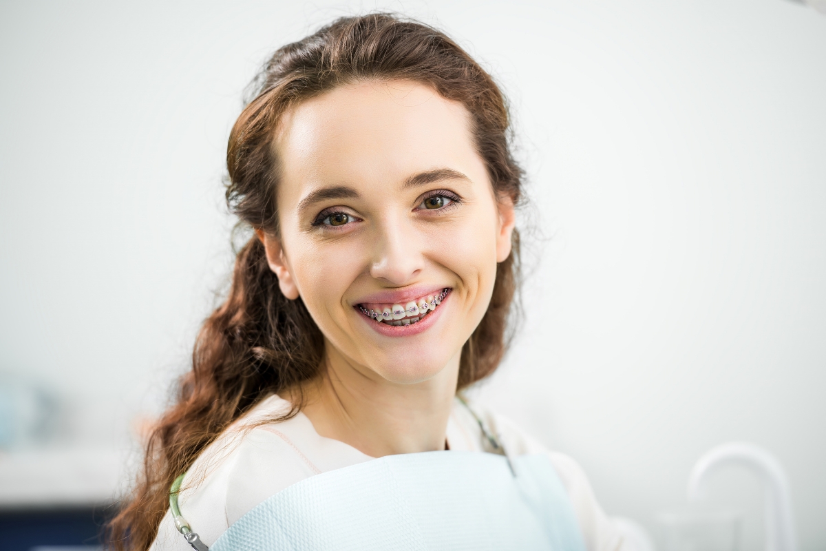Woman smiling with braces while learning how to prevent white spots on teeth